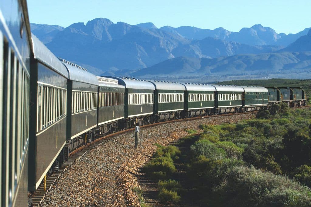 The Rovos Rail in South Africa with mountains in the background.